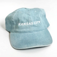 Load image into Gallery viewer, A light blue washed cotton baseball cap with 'KANSAS CITY' embroidered in white on the front, shown on a plain white background.