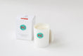 Load image into Gallery viewer, A white ceramic candle jar with a teal circular KC logo wax seal, shown next to its white packaging box on a clean white background.