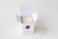 Load image into Gallery viewer, A white wax candle in a white open box with a purple circular logo reading CATS, shown on a clean white background with the lid placed beside the box.