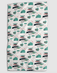 Load image into Gallery viewer, A white kitchen towel featuring a repeating pattern of the Kansas City skyline, the KC Current stadium, and a teal KC heart, including text that reads "TEAL TOWN" and "CURRENTLY MAKING HISTORY"