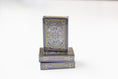 Load image into Gallery viewer, A stack of Kansas City Playing Cards in a black box with gold and white geometric designs, photographed on a clean white background.