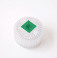 Load image into Gallery viewer, A clear ribbed glass round container with a green diamond-shaped label on top featuring a black symbol and the text 'MERSEA Co'.