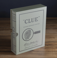 Load image into Gallery viewer, Vintage Bookshelf Edition Clue board game box, featuring a classic vintage design with a fingerprint magnifying glass illustration on the front, set on a wooden surface against a dark background.