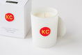 Load image into Gallery viewer, Close up on white candle vessel with a red and yellow wax seal, which features "KC" to represent the KC Chiefs
