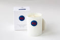 Load image into Gallery viewer, A white ceramic candle jar with a blue circular 'KU' logo sits next to its white packaging box on a clean white background.
