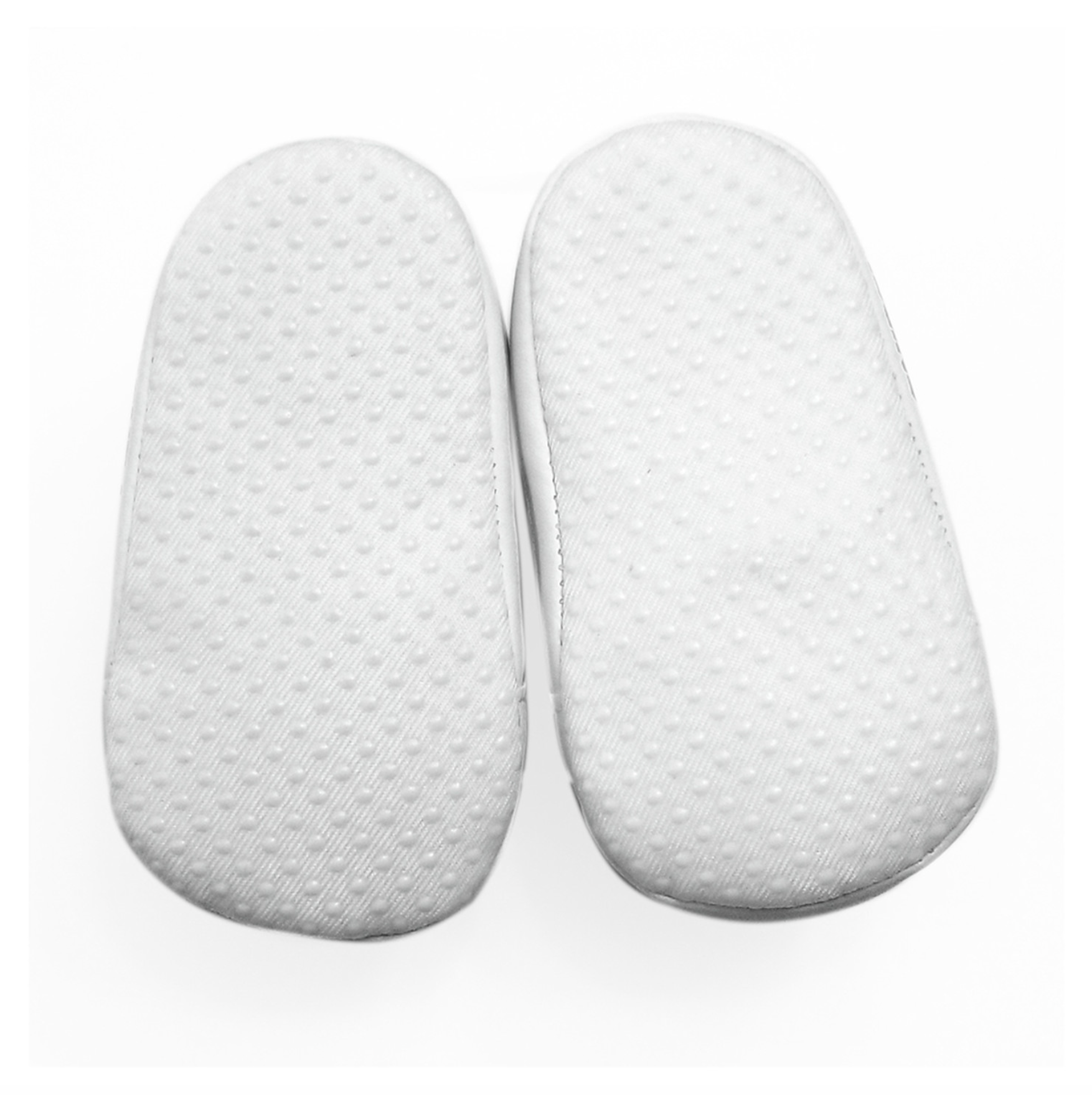 A pair of white soles with a textured, dotted grip pattern belonging to baby shoes, shown from a top-down view on a white background.