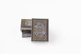 Load image into Gallery viewer, A deck of playing cards with a dark gray and gold map design, standing upright next to two stacked decks on a white background.

