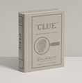 Load image into Gallery viewer, A vintage-style bookshelf edition of the board game Clue, shown standing upright on a neutral light gray background. The book features a gray cover with brown printed text and a magnifying glass fingerprint graphic.
